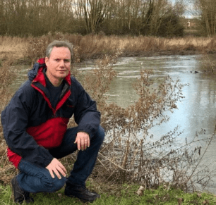 Cllr Andrew Prosser inspecting polluted river in Witney
